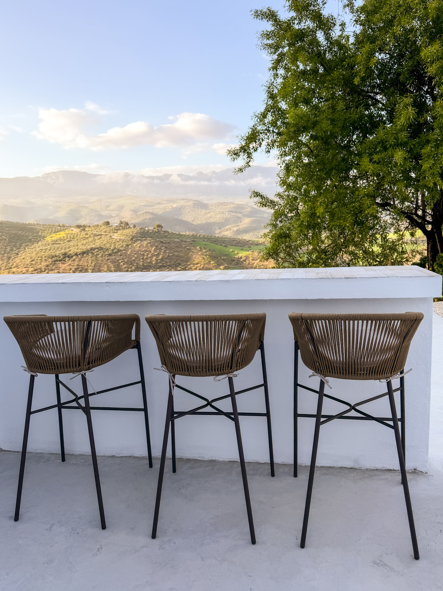 Outdoor bar with rattan stools overlooking the Andalucian mountains