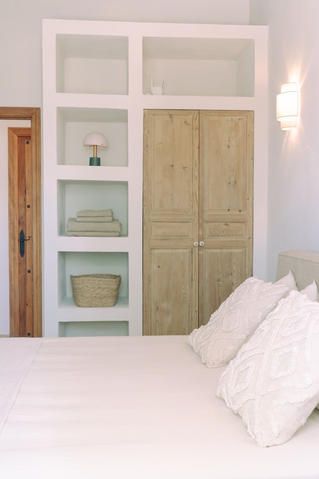 Bedroom with built-in niches, wooden wardrobe doors and linen bedding